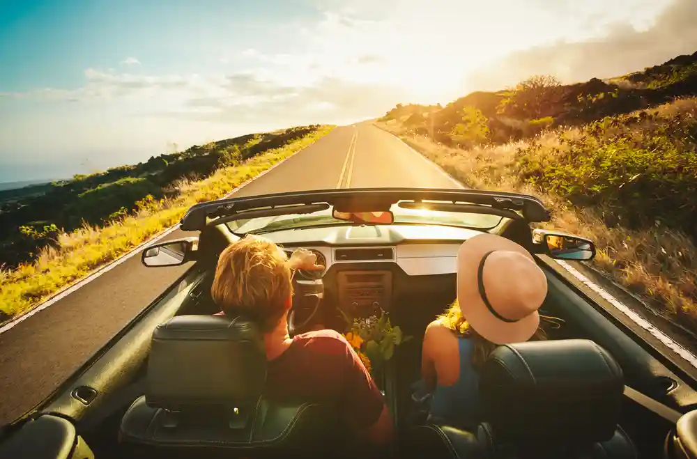 couple driving alongside beach highway